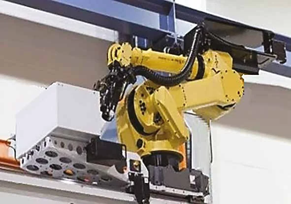 Anthropomorphic robot on an aerial rail moving tools between the tool room and the machines