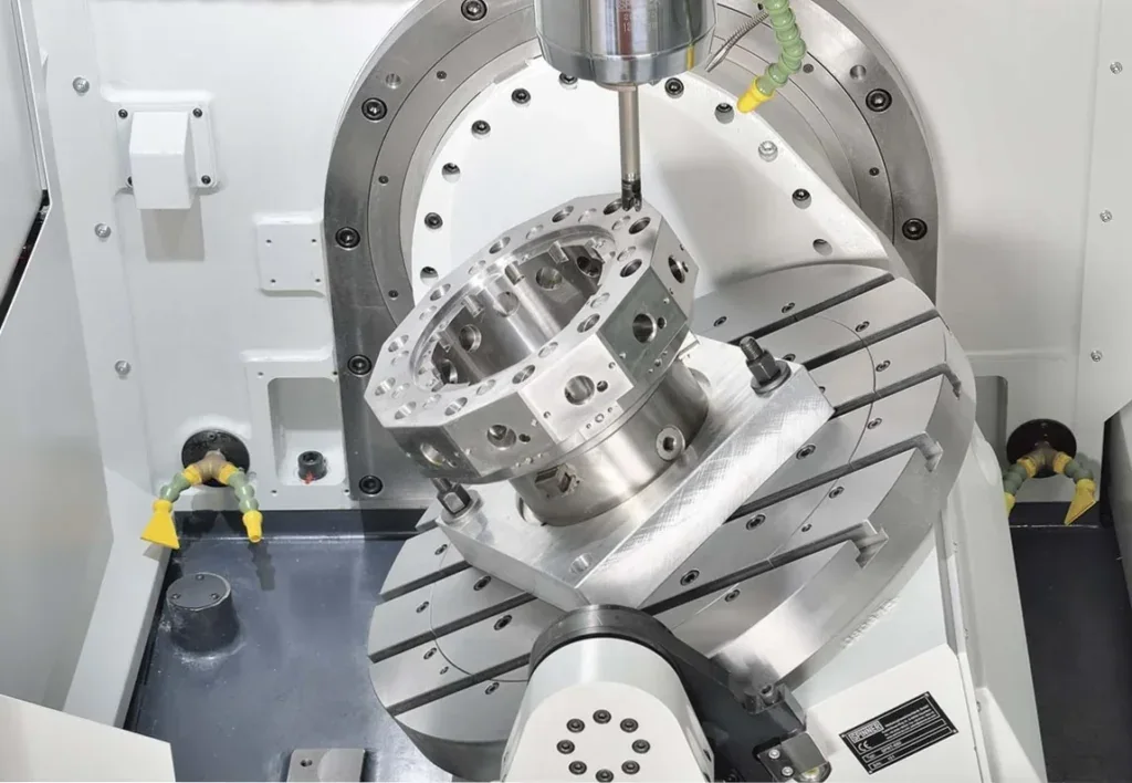 Spinner U5-630 work area: octagonal part clamped on the tilted rotary/tilting table, spindle cutting from above