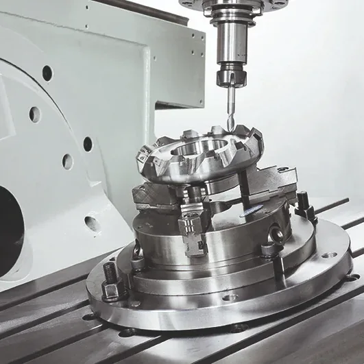Spinner U5 work area: part held in a chuck on the table, drilled from above